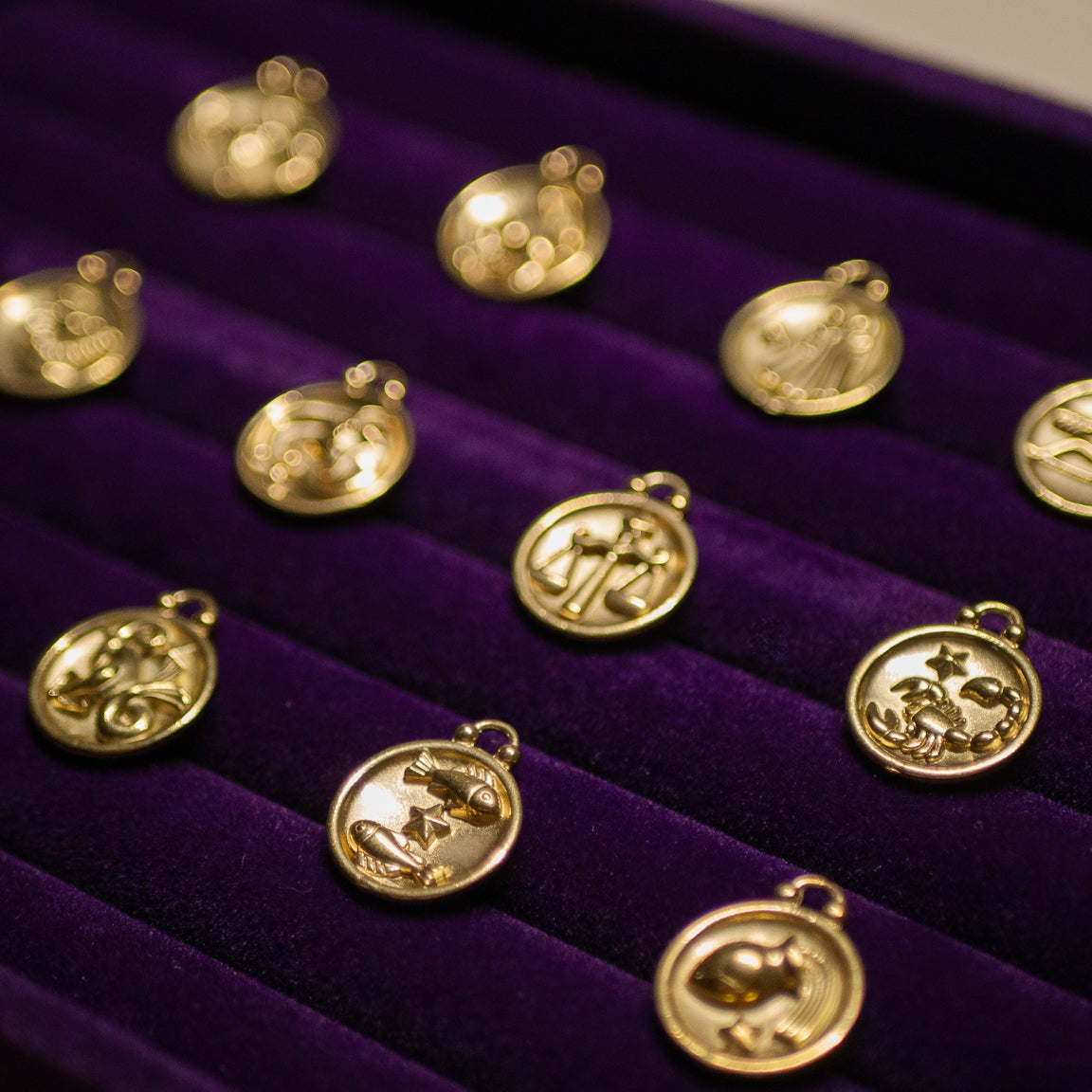 Gold pendants on a purple velvet display box