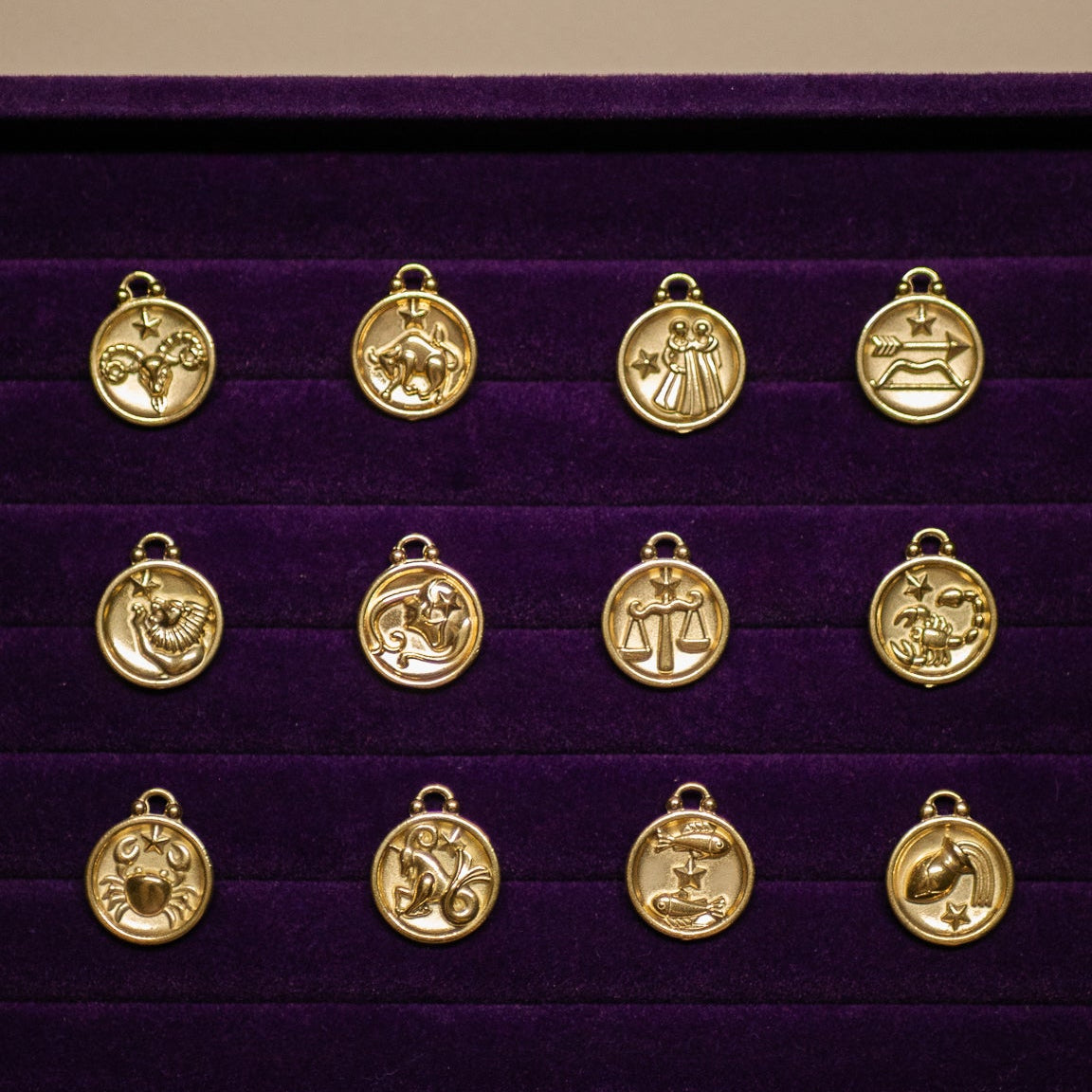 Gold zodiac pendant set on a purple display box